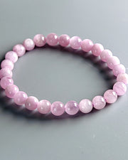 Pink beaded bracelet on a gray background